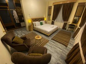 罕萨Dumani Nagar Hotel & Resort的酒店客房配有一张床、一张沙发和椅子。