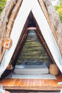 巴鲁岛Santuario Beach Hostel的帐篷内的一张床位,配有木制甲板