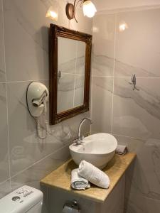 纳夫普利翁迈拉尔宾馆的一间带水槽、镜子和卫生间的浴室