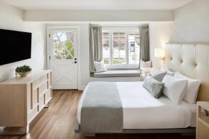 太平洋丛林翠绿庄园旅馆，四姐妹旅馆的白色卧室设有一张大床和电视。