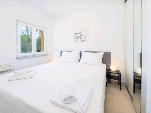 奥米沙利Adriatico的白色的卧室设有白色的床和窗户。