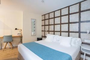 马拉加麦迪瑞奈酒店的卧室配有一张白色大床和一张书桌