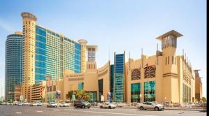 阿布扎比Corniche AD - Luxury Room的停车场内停放汽车的大型建筑