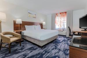 休斯顿休斯顿威斯切斯费尔菲尔德套房客栈的酒店客房配有一张床、一把椅子和一台电视。