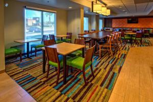 奥兰多万豪奥兰多环球影城费尔菲尔德套房酒店的餐厅设有木桌和绿色椅子