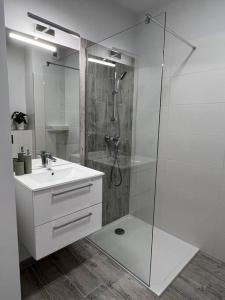华沙Apartment Olive in Białołęka-Tarchomin Center的带淋浴和盥洗盆的白色浴室