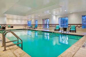 夏洛特夏洛特南方公园原住客栈的一个带蓝色椅子的酒店客房的游泳池