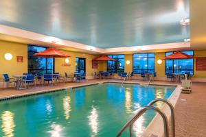 韦恩堡韦恩堡北万豪广场套房酒店的一座配有桌椅的酒店游泳池