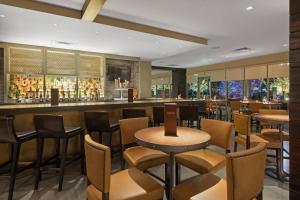 博尔德Boulder Marriott的餐厅设有酒吧,配有桌椅