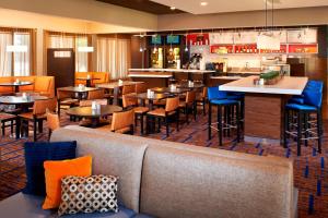 罗克福德罗克福德万怡酒店的一间带桌椅的餐厅和一间酒吧