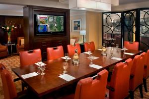 Trumbull特朗布尔谢尔顿万豪酒店的一间带长桌和橙色椅子的用餐室