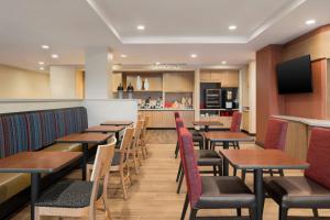 迪比克TownePlace Suites by Marriott Dubuque Downtown的一间带木桌椅的餐厅和一间厨房