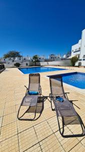 圣卢西亚岛Santos Apartment的游泳池旁的两把椅子