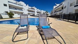 圣卢西亚岛Santos Apartment的游泳池旁的两把沙滩椅