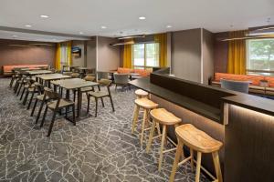 圆石城斯普里赫尔套房酒店－奥斯汀罗德罗克的一间带桌椅的餐厅和一间酒吧