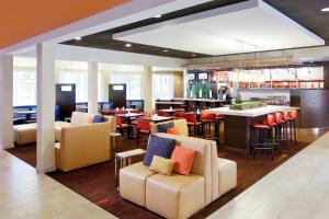 萨克拉门托纳透马斯萨克拉门托机场万怡酒店的一间带桌椅的餐厅和一间酒吧