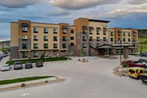 利特尔顿Fairfield by Marriott Inn & Suites Denver Southwest, Littleton的停车场内停放汽车的大型建筑