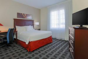 埃尔森特罗埃尔森特罗唐普雷斯套房酒店的酒店客房配有一张床、一张书桌和一台电视。