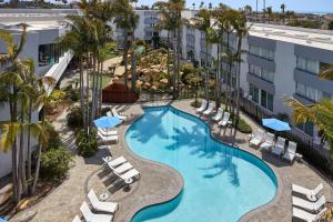 文图拉万豪文图拉海滩酒店的享有带椅子和棕榈树的游泳池的顶部景致
