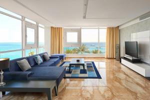赫尔格达Hurghada Marriott Beach Resort的客厅配有蓝色的沙发和电视