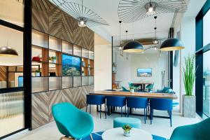 卢顿Courtyard by Marriott Luton Airport的一间配备有蓝色椅子和桌子的用餐室