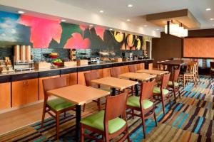 曼彻斯特曼切斯特哈特佛德费尔菲尔斯客栈&套房酒店的餐厅设有木桌和绿色椅子