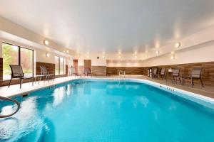 曼彻斯特曼切斯特哈特佛德费尔菲尔斯客栈&套房酒店的一座配有桌椅的酒店游泳池
