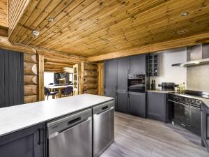 奈斯桥Mountain Bear Lodge的厨房配有灰色的橱柜和木制天花板