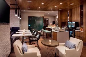 尔湾尔湾万豪酒店的一间设有白色桌椅的餐厅和一间酒吧