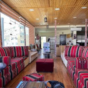 瓦迪穆萨Petra cabin Roof top hostel的客厅配有红色的沙发和桌子