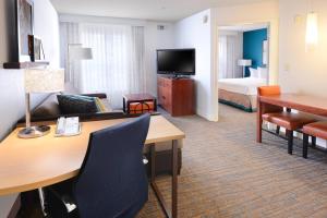 普莱诺Residence Inn by Marriott Dallas Plano/Legacy的酒店客房设有书桌和卧室。