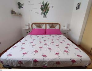 圣特奥多罗Casa Flamingo House的一张带粉红色床罩的床,上面有火烈鸟