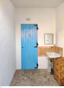 圣特奥多罗Casa Flamingo House的一个带水槽的浴室内的一扇蓝色门