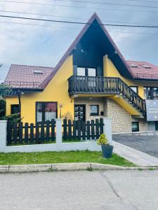 乌斯特龙Domek pod Czantorią的黄色和蓝色的房屋,设有木栅栏
