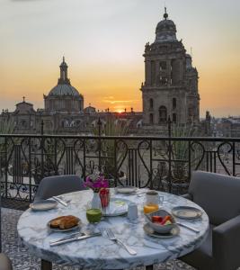 墨西哥城Zocalo Central & Rooftop Mexico City的一张桌子,上面有食物,享有建筑的景色