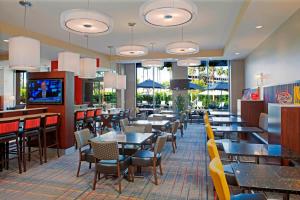 洛杉矶洛杉矶国际机场/世纪大道万豪酒店 的用餐室设有桌椅和窗户。