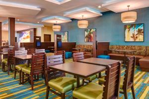 卡尔斯巴德圣迭戈卡尔斯巴德费尔菲尔德酒店的餐厅设有桌椅和沙发。