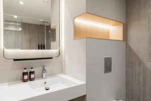 多特蒙德Residence Inn by Marriott Dortmund City的一间带水槽和镜子的浴室
