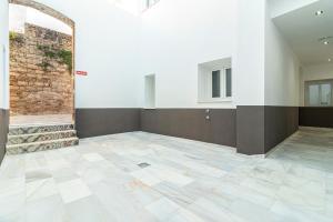 赫雷斯-德拉弗龙特拉Top & Chic Albarizuela Suites - Apartamentos Jerez的一间空房间,有砖墙和瓷砖地板