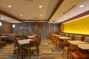 劳德代尔堡Fairfield Inn & Suites By Marriott Fort Lauderdale Downtown/Las Olas的一间设有桌椅的用餐室和黄色的墙壁