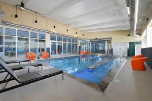 拉伯克Aloft Lubbock的一座大型游泳池,里面设有橙色椅子