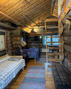 伊纳利Log Cabin - Lord of Sormuset的小屋内一间卧室配有一张床和一张双层床。