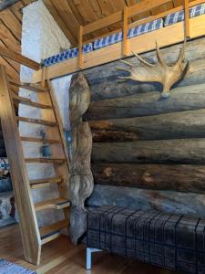 伊纳利Log Cabin - Lord of Sormuset的一间设有楼梯和一面带小木屋的墙壁的房间