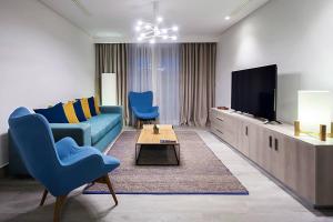 苏塞Sousse Pearl Marriott Resort & Spa的客厅配有蓝色的沙发和电视