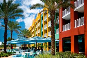威廉斯塔德Renaissance Wind Creek Curacao Resort的拥有蓝色遮阳伞、桌子和棕榈树的酒店