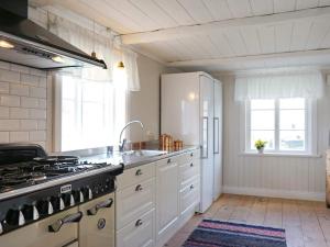 HedekasHoliday home HEDEKAS II的厨房配有白色橱柜和炉灶烤箱。