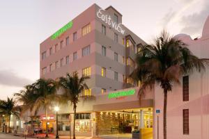 迈阿密海滩迈阿密南海滩万怡酒店的前面有棕榈树的酒店