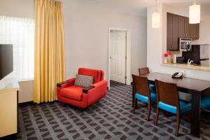 嘉年TownePlace Suites by Marriott Phoenix Goodyear的客厅配有红色椅子和餐桌