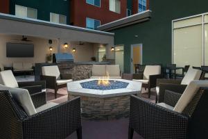 莫德斯托Residence Inn by Marriott Modesto North的一个带火坑和椅子的庭院以及一台电视