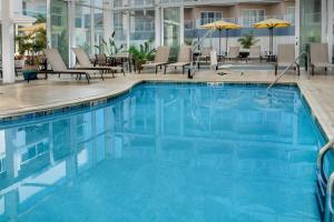 大洋城海洋城海滨万怡酒店的游泳池,带椅子和遮阳伞